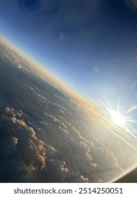 View from plane over ocean with clouds and water sun setting and night fall over the city 