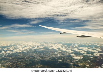 View from the plane window to the clouds and the earth