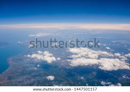View from the plane window on the cloudy landscape of the earth