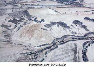 The View From The Plane Window To The Snowy Siberia. View Of The Snow-covered Fields. The Texture Of The Winter Landscape From The Side Of The Plane.