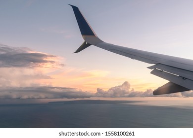 View from a plane window at sunset with the wing in the frame. Beautiful colors, peaceful view.