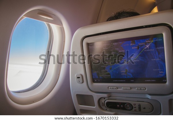 View of plane\'s cabin windows seat with beautiful\
scenic view and screen monitor show map destination landing to\
Tokyo.\
Seat airplane and window view inside an aircraft.\
Monitor\
& window on plane.