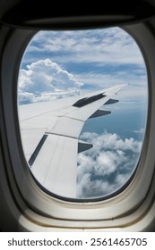 View of the plane's wing and beautiful clouds through the window during the flight.
