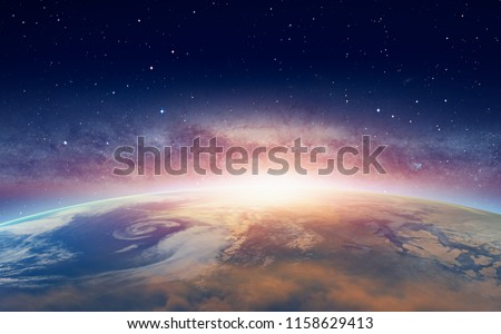 View of the planet Earth from space during a sunrise against milkyway galaxy 