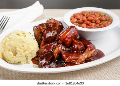 A View Of A Plate Of Barbecue Rib Tips With Sauce, In A Restaurant Or Kitchen Setting.