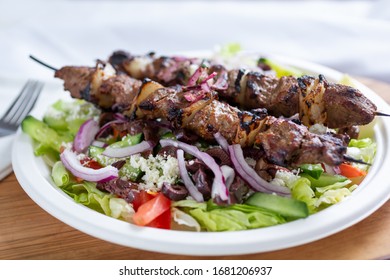 A View Of A Plate Of Beef Shish Kabob On A Salad.