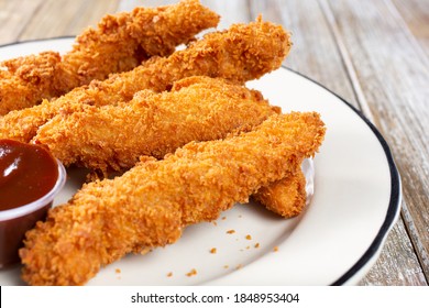 A View Of A Plate Of Breaded Chicken Fingers.