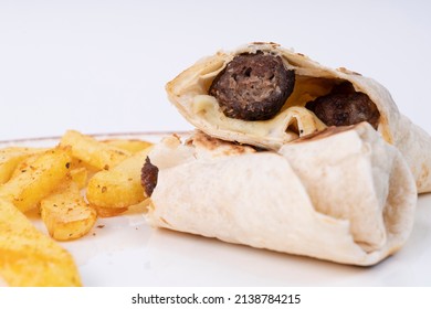 View of plate of wrap and french fries shot from side or opposite angle with selective focus on white background in isolated setting.
Image of wrap meal and french fries.