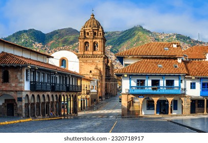 View of the Plaza Mayor and Basilica Menor church in the Old town of Cusco city, and the Andes mountains, Peru. Plaza Mayor is the main square of Cuzco, famous for historical colonial architecture.