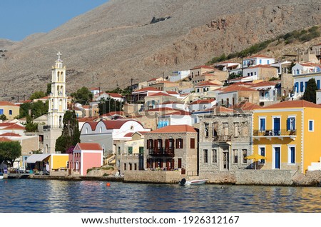 View of the port of the Greek island of Chalki with the typical colored houses in the Dodecanese archipelago