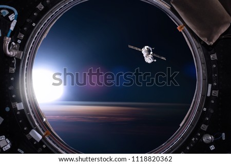 View from a porthole of space station on the Earth background. Elements of this image furnished by NASA.