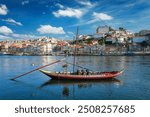 View of Porto city and Douro river with traditional boat with port wine barrels from famous tourist viewpoint Marginal de Gaia riverfront. Porto, Vila Nova de Gaia, Portugal