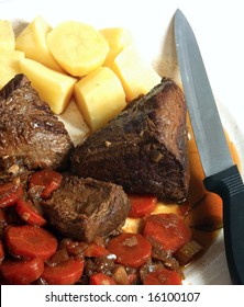 View Of A Pot Roast (or Braised Steak) On A Platter, With The Vegetables It Was Cooked In And Boiled Potatoes, Ready For Serving.