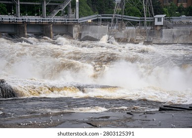 View of powerful river rapids below hydroelectric dam.