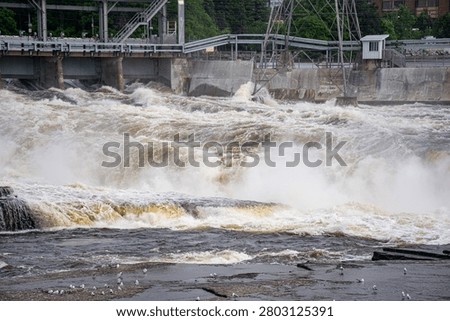 View of powerful river rapids below hydroelectric dam.