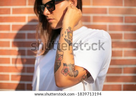 View of pretty young woman with tattooed hand