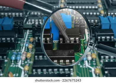 view of printed circuit board with active and passive surface mounted components close up through magnifying glass - Powered by Shutterstock