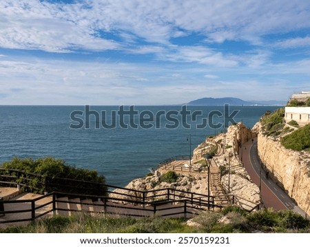 View of the promenade between rocks next to the Mediterranean Sea in Cala del Moral (Málaga, Spain) on a sunny winter morning