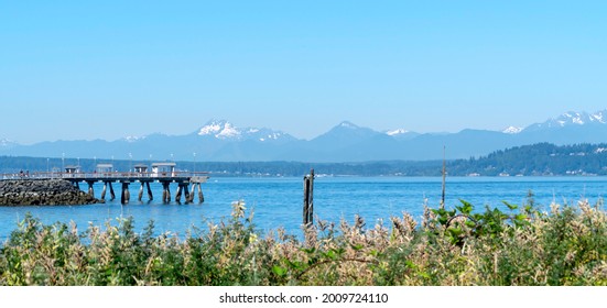 View of Puget Sound between the city of Edmonds in Washington State and Olympic Mountains on the peninsula in the west. On the left of the photo is the Edmonds pier used by sightseers and fishers.