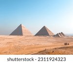 View of pyramids of giza with locals walking in their camels