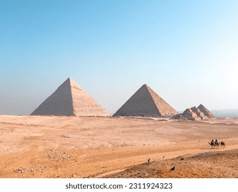 View of pyramids of giza with locals walking in their camels