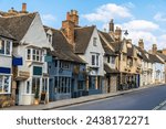A view up a quaint street with wonky buildings in Stamford, Lincolnshire, UK in springtime