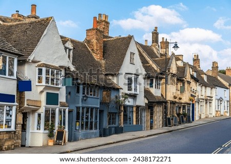 A view up a quaint street with wonky buildings in Stamford, Lincolnshire, UK in springtime