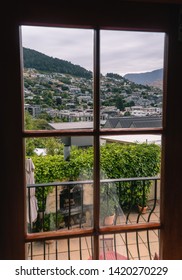 View Of Queenstown City From Glass Window Door Of Luxury Hotel Balcony. Shot In New Zealand, NZ