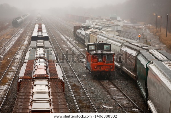 View of rail yard on\
a wet and foggy day.