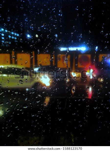 A view of a rainy\
night from inside a bus