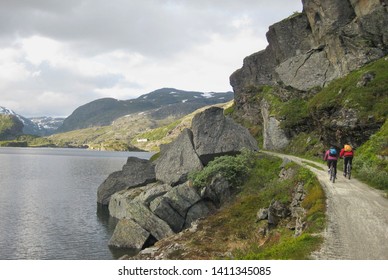 View Of Rallarvegen With Bikers On Road. Famous Bicycle Trail On Hardangervidda Plateau Leads You Along The Bergen Railway Line From Haugastøl To Flåm. Norway