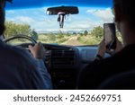 View from the rear of a car, pair of friends traveling in Los Gigantes area, a mountain tourist destination for hiking, trekking, in Cordoba, Argentina