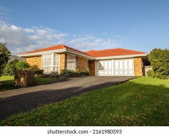 View of red brick and tile suburban house. Auckland, New Zealand - May 20, 2022