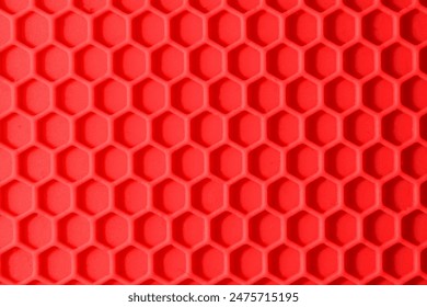 It's view of red ribbon honeycomb cells background. It's a flat lay view of plastic honeycomb background. Its macro photography of pink hexagon cells.