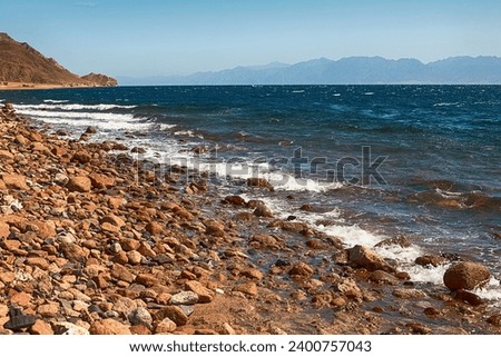View of the Red Sea shore, pebble beach and kami close-up. Leisure concentration. Egypt, Dahab