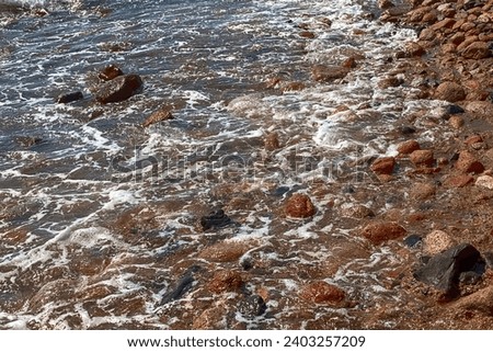 View of the Red Sea shore, pebble beach and kami close-up. Leisure concentration. Egypt, Dahab