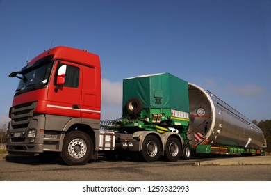 View Of A Red Truck, Low-loader Semi-trailer And Oversized Load.