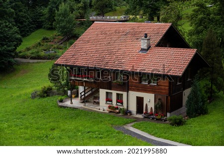 View of a red wooden chalet farm house situated at the alpine village of Hasliberg ,Switzerland.