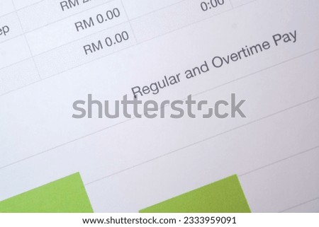 View of a regular and overtime pay sheet paper, with a concept of providing compensation for labor work