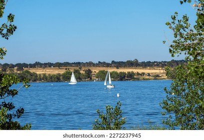 A view of the Reservoir at Cherry Creek State Park in Summertime through the cottonwoods that line the trails by the lakeside. Park is located in Arapahoe County, Colorado close to Denver.