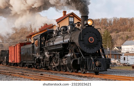 View of a Restored, Antique Steam Freight Train Approaching in Early Morning, on old Narrow Gauge Tracks on a Winter Day, Blowing Smoke - Powered by Shutterstock