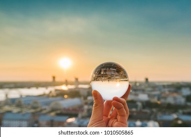 View of Riga through a glass ball, summer sunset time. Riga is the capital and the largest city of Latvia