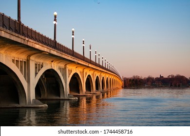 View of the right side of the MacArthur bridge from the ground under bridge. The bridge links downtown Detroit and Belle Isle Michigan State Park and serves as the entrance. Beautiful sunrise glow.