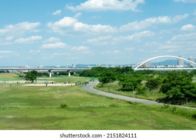 View Of The  Riverside Park With Young Baseball Team Practicing And City In Background