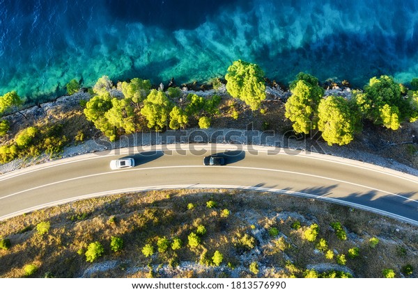 View of the road along the coast from the drone.\
Travel by car in summer time. The sea coast and the road. The coast\
of Europe.