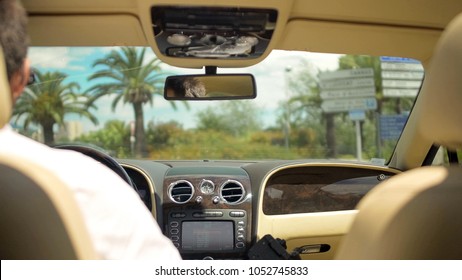 View Of Road From Backseat Of Luxury Vehicle, Business Driver Behind Wheel