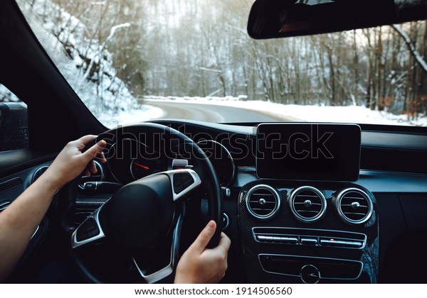 View of the road, drivers view. Man driving on a\
snowy mountain road
