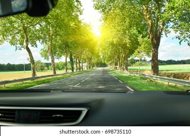 View of the road and forest through the windshield of the car Sunshine