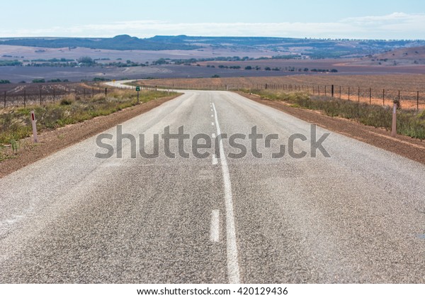 View of Road leading into the distance outback\
at western Australia