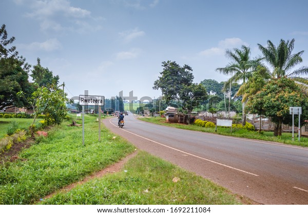 View of a road\
passing through a small town with house’s and vehicles, Rweteera,\
Fort Portal, Uganda,\
Africa\
